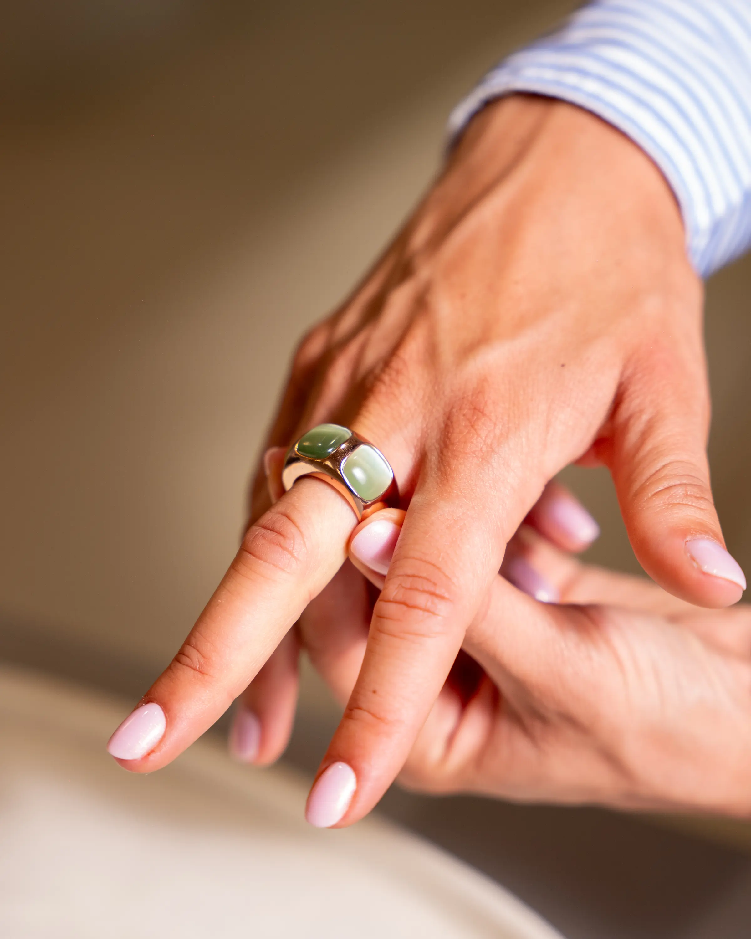 Anello a fascia con pietre verdi, infilato al dito