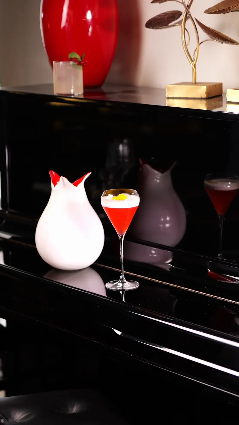 Due cocktail su una mensola scura, fra i vasi di ceramica del locale
