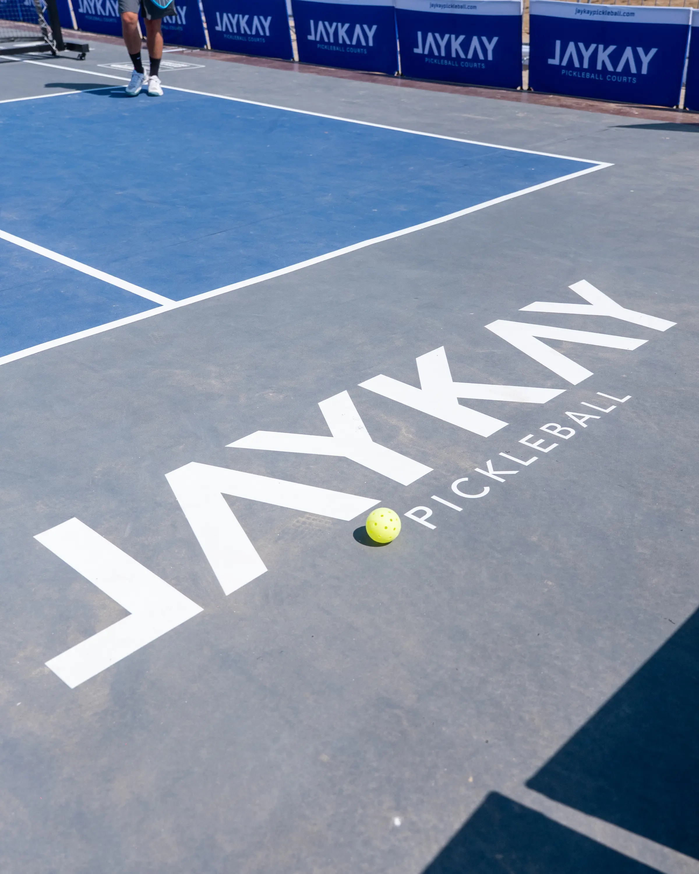 Il marchio JAYKAY Pickleball stampato sul campo, con una pallina sulla riga