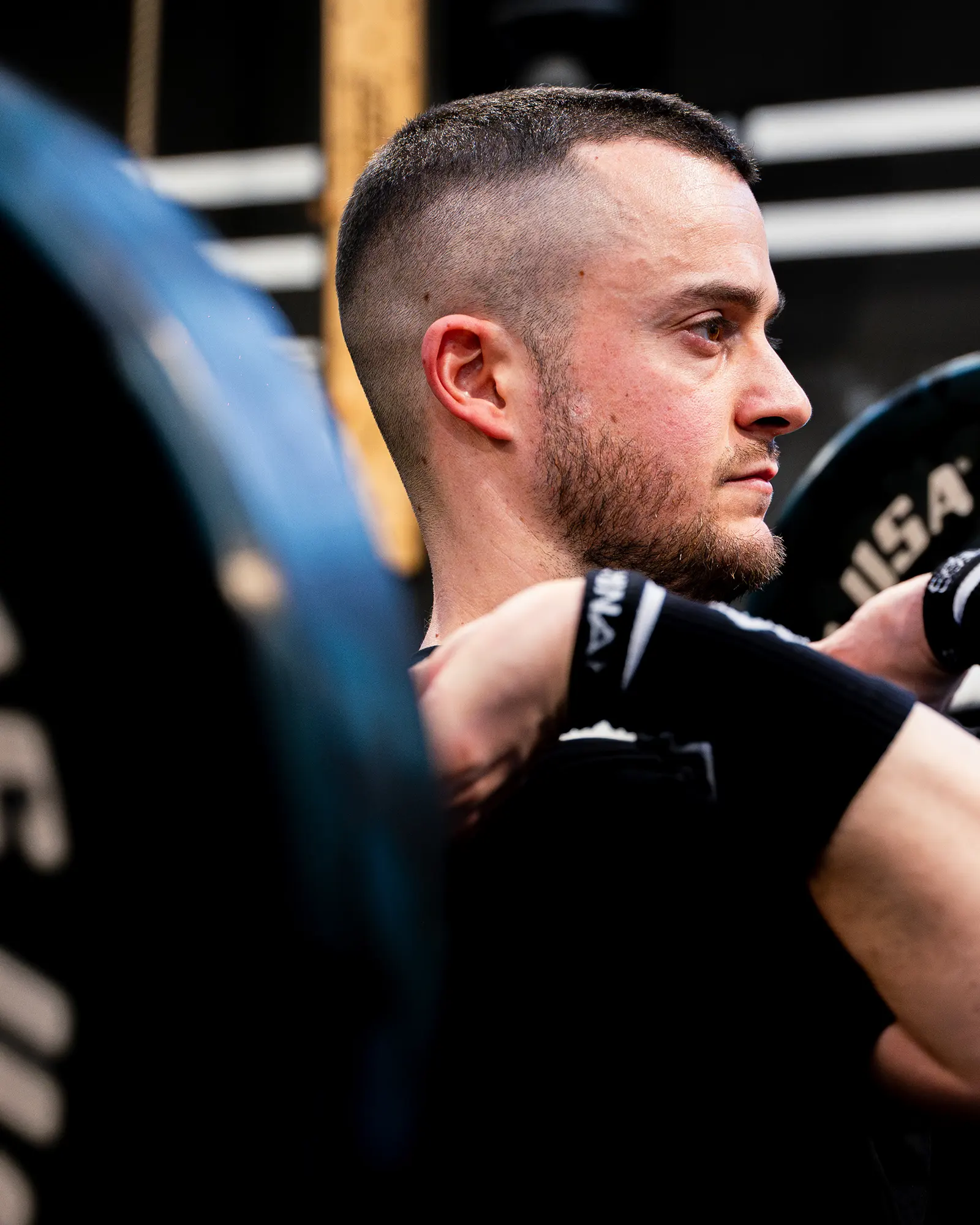 Ritratto di profilo dell’atleta con bilanciere sulle spalle